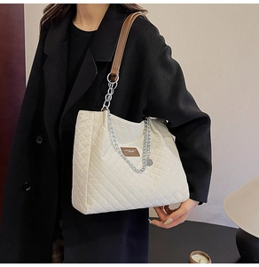 Détail du sac cabas matelassé beige en nylon avec chaîne en métal et empiècement cuir