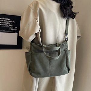 Minimalist corduroy tote bag in olive green with dual exterior pockets and crossbody strap