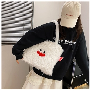 Détail du sac à bandoulière en peluche blanche avec broderie monstre et fausse fourrure