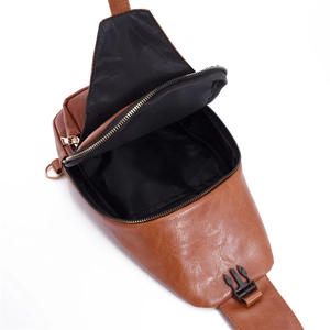Detail view of the open interior space and black lining of the brown PU leather crossbody bag
