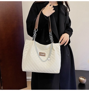 Détail du grand sac cabas matelassé blanc avec chaîne argentée et logo en cuir marron