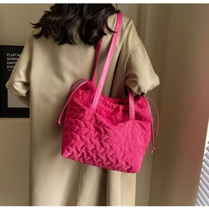 Detail of hot pink quilted tote bag with leaf-like textures and adjustable drawstring