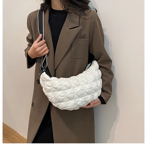 Dettaglio della borsa a mezzaluna in nylon trapuntato bianco con ampia tracolla a contrasto