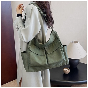Detail view of army green canvas messenger bag with large utility pockets and wide strap