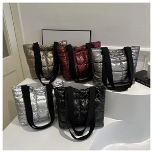 Detailed display of quilted down tote bags in various metallic colors on white steps