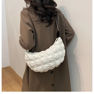 Dettaglio della borsa a mezzaluna trapuntata bianca con trama in nylon e tracolla nera