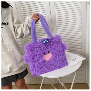 Détail du sac cabas en peluche violette avec motif visage de monstre et nœud à pois bleus