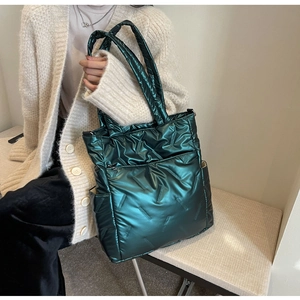 Detail view of the deep green metallic quilted tote bag texture and soft nylon material