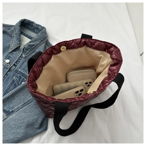 Interior view of wine red quilted handbag showing magnetic clasp and spacious storage
