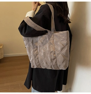 Close-up of silver-grey quilted tote bag with silk-gloss nylon and diamond lattice texture