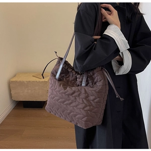 Brown leaf-quilted puffer tote bag with drawstring closure and slim dark handles