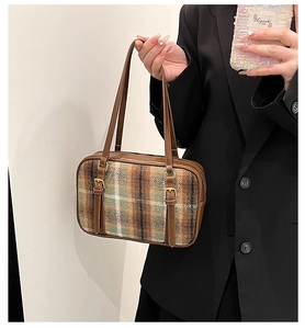 Detail view of retro plaid wool shoulder bag with brown leather trim and golden buckles