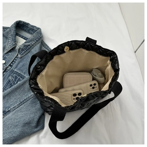 Top view showing the spacious interior and magnetic clasp of this black quilted tote bag