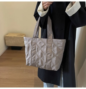 Close-up of quilted tote bag in light grey nylon with elegant diamond pattern