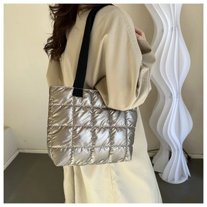 Close-up of a silver quilted puffer tote bag featuring a modern metallic finish