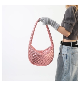 Detailed side view of pink metallic quilted half-moon clutch with premium stitching