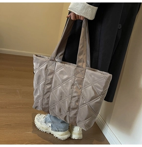 Close-up of champagne quilted fabric tote bag with glossy finish and large diamond stitching