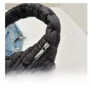 Détail de la fermeture éclair argentée sur un sac cabas matelassé noir à texture bouffante