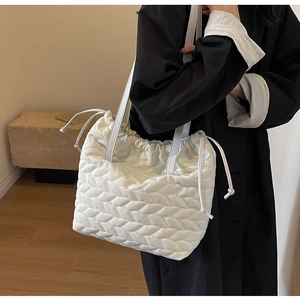 Close-up of a white quilted tote bag with cloud-like pleats and drawstring detail