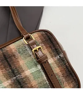 Close-up of retro plaid wool fabric and premium brown leather trim on shoulder bag