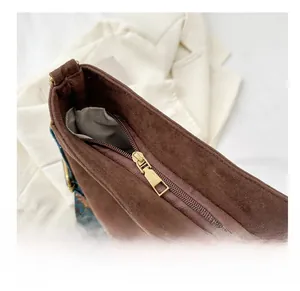 Detail of smooth metal zipper and brown suede material on trendy crossbody bag