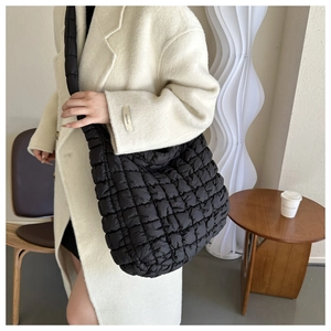 Détail du sac hobo matelassé noir avec bandoulière rembourrée et texture à losanges