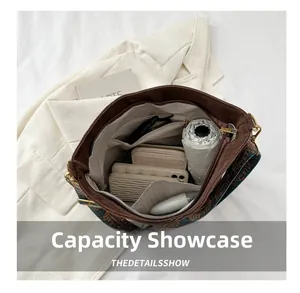 Detail view of large capacity interior with ethnic woven strap on brown tote bag