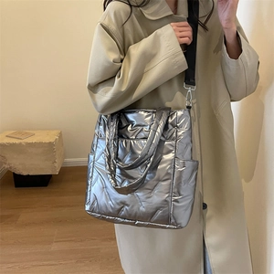 Chic silver quilted tote bag with metallic finish and wide crossbody shoulder strap