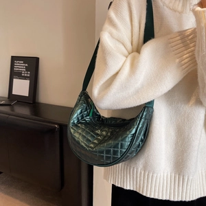 Deep green metallic half-moon crossbody bag with quilted diamond pattern and long strap