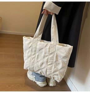 Detail of off-white quilted tote bag with large diamond stitching and soft silk luster