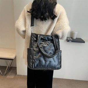 Fashionable black quilted puffer tote bag in glossy nylon with adjustable crossbody strap
