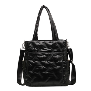 Black quilted high-capacity tote bag with adjustable shoulder strap and glossy finish