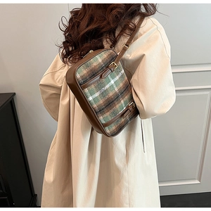 Detail of vintage plaid shoulder bag in green and brown wool with leather trim