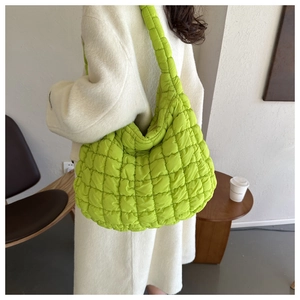 Vue détaillée du grand sac nuage matelassé vert fluo porté sur un manteau en cachemire