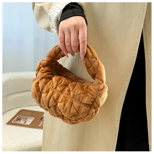 Close-up of caramel plush dumpling bag featuring soft pleated texture and velvet finish