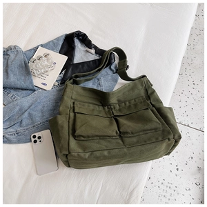 Detail of olive green canvas crossbody bag with two functional front flap pockets
