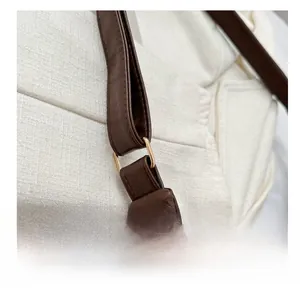 Detail of dark brown leather tote bag with golden D-ring hardware and pebble texture