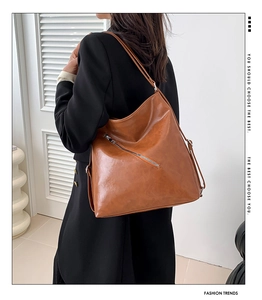 Détails d'un grand sac cabas en similicuir marron avec fermetures éclair décoratives chic