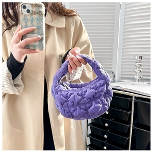 Close-up of bright purple quilted cloud bag showing soft pleated texture and handle details