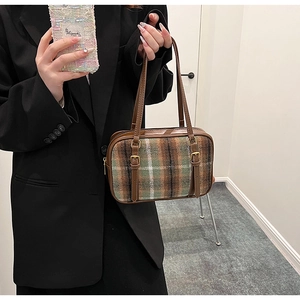 Detail of retro plaid shoulder bag with brown leather strap and wool fabric texture