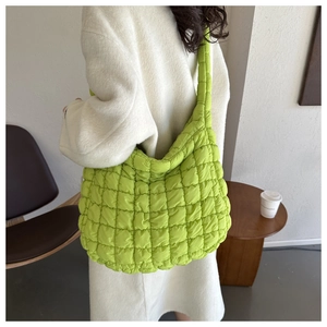 Vue détaillée du sac cabas matelassé vert fluo porté sur un manteau blanc pour femme