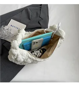 Spacious interior of white quilted shoulder bag showing tablet, umbrella, and phone storage