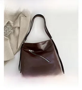 Vue détaillée du sac en cuir PU marron foncé avec fermeture éclair argentée oblique