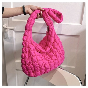 Detailed macro view of vibrant pink quilted puff handbag fabric with soft bubble texture
