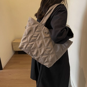 Quilted taupe tote bag with large diamond stitching and wide shoulder strap