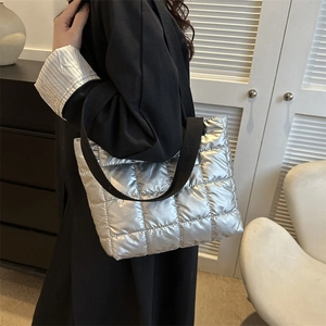 Metallic silver quilted puffer handbag with a black wide shoulder strap for women