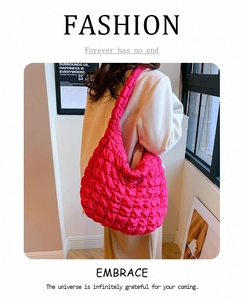 Detail of hot pink quilted cloud bag showing the pleated fabric texture and wide strap