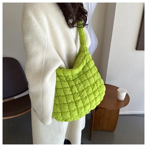 Détail du sac à bandoulière en nylon matelassé vert clair montrant la texture douce