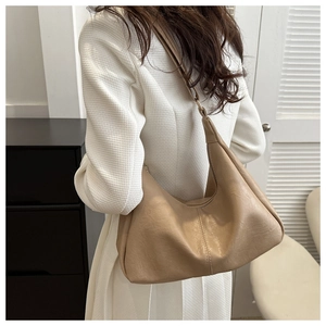 Close-up of khaki PU leather hobo bag with pebble texture and shoulder strap on model