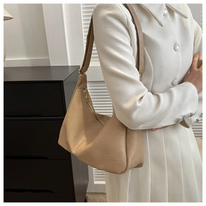 Detail showing the creamy beige PU leather hobo bag with a soft lychee grain texture